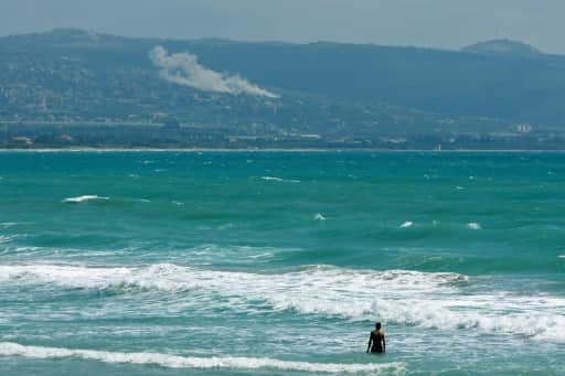 Une personne prend un bain de mer face au village d'El Mansouri, dans le sud du Liban, pendant un bombardement israélien le 22 mai 2026