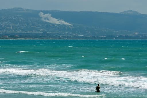 Une personne prend un bain de mer face au village d'El Mansouri, dans le sud du Liban, pendant un bombardement israélien le 22 mai 2026