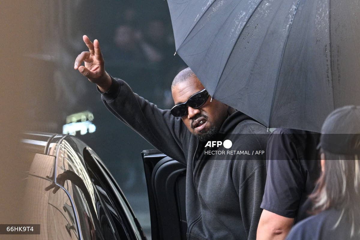 Le rappeur américain Kanye West, lunettes noires et parapluie