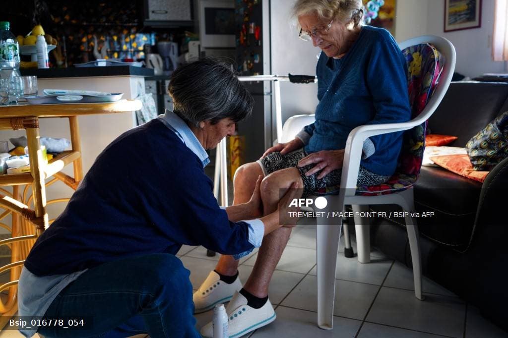 Infirmiere prodiguant des soins a une personne agee a son domicile en France