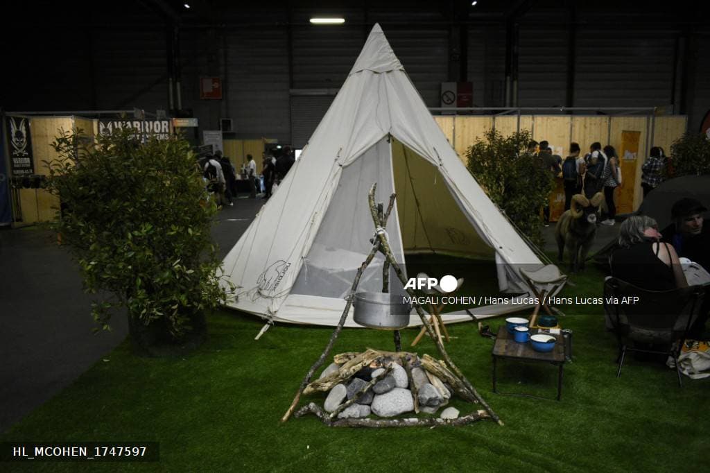 Stand de salon du survivalisme en France avec tipi et materiel de camping