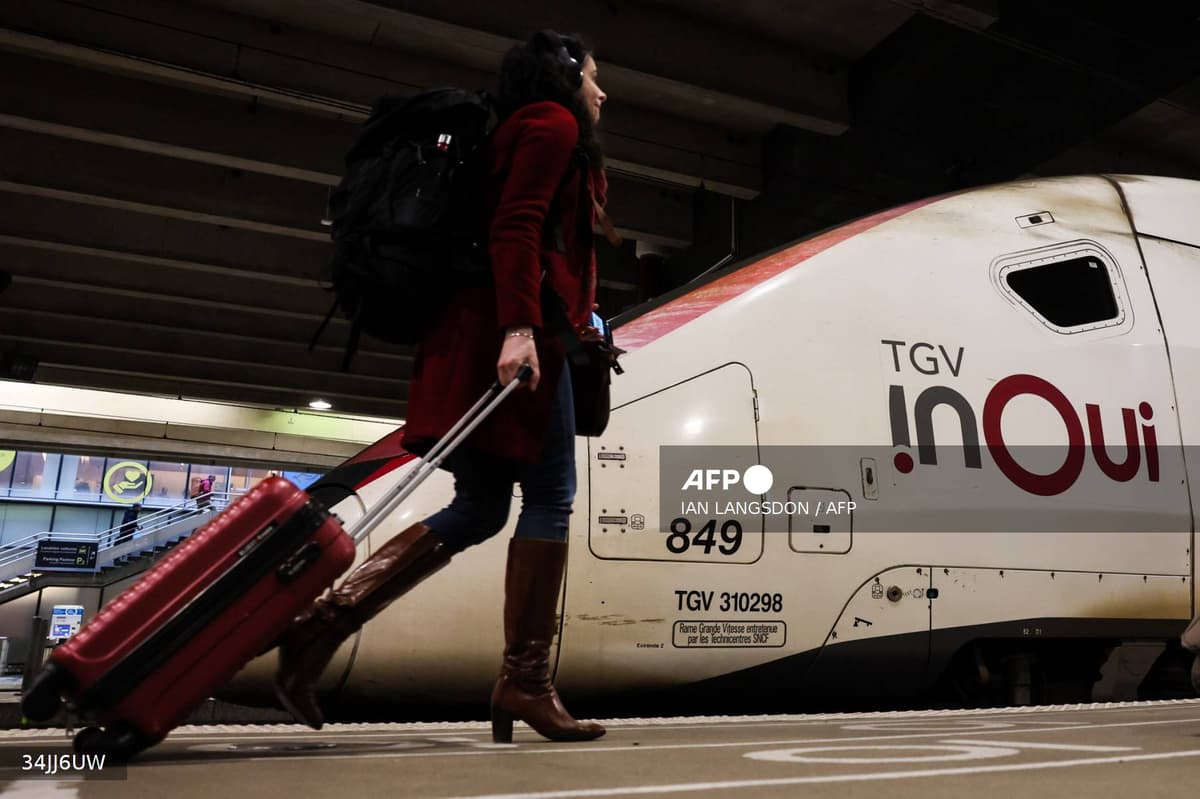 Voyageuse avec valise devant un TGV INOUI en gare pour les vacances de Paques 2026