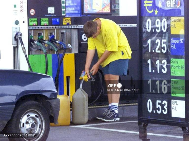 Un automobiliste remplit un jerrican de carburant dans une station-service en France