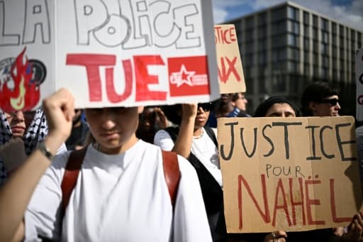 Des manifestants brandissent des pancartes Justice pour Nahël et La police tue lors d'un rassemblement