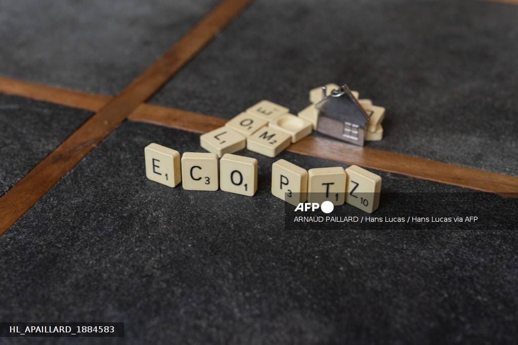 Lettres de Scrabble formant ECO PTZ à côté d'un porte-clés en forme de maison