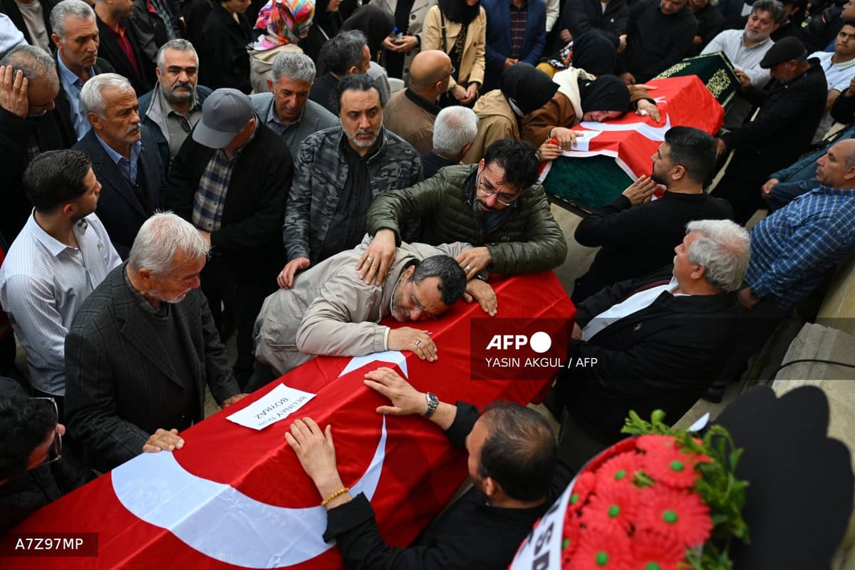 Proches d'une victime en pleurs sur un cercueil drapé du drapeau turc lors des funérailles à Kahramanmaras le 16 avril 2026