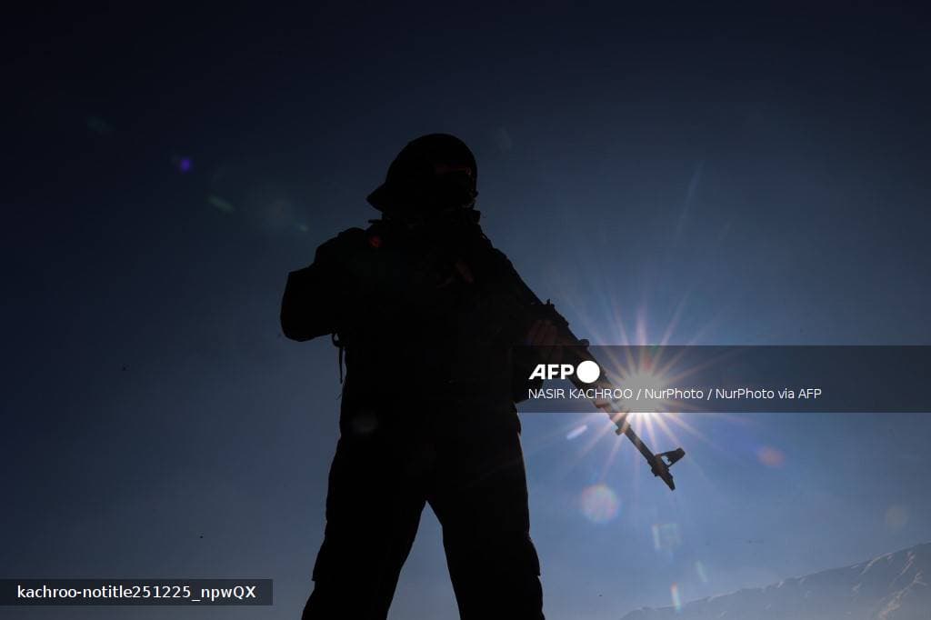 Silhouette d'un membre des forces de sécurité en contre-jour dans le Cachemire sous administration indienne en décembre 2025