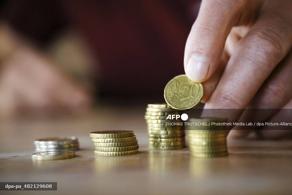 Pièces et billets devant un porte-monnaie — symbole du calcul de retraite et du pouvoir d'achat des seniors