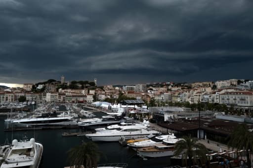 Des yachts de luxe amarrés dans le port de Cannes sous un ciel d'orage
