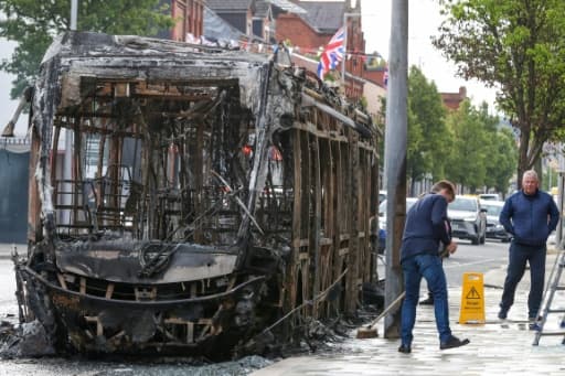 Un bus calciné après une nuit de violences dans l'est de Belfast, en juin 2026.