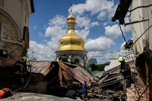 Pompiers sur le toit de la cathédrale de la Dormition endommagée à Kiev