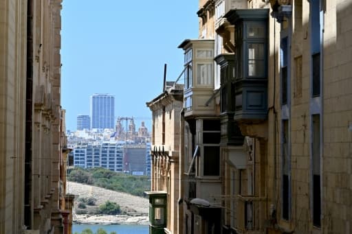 Rue de La Valette à Malte : façades traditionnelles en calcaire doré au premier plan, tours modernes en arrière-plan