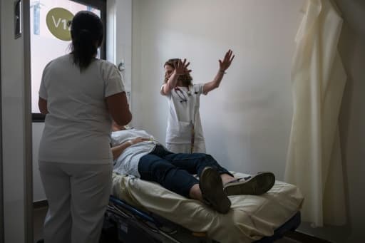 Une soignante au chevet d'une patiente à l'hôpital