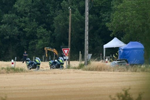 Motos et véhicules de gendarmerie, tentes d'expertise et pelleteuse sur le site des recherches dans le Tarn