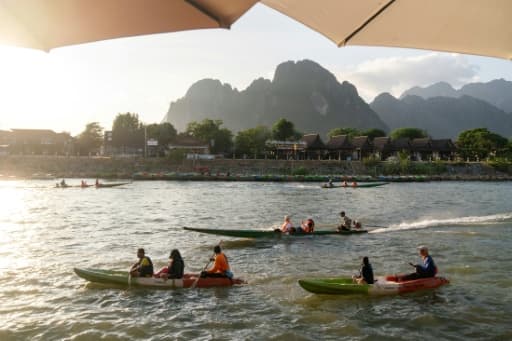 Des touristes naviguent sur la rivière Nam Song à Vang Vieng, au Laos, destination prisée des routards