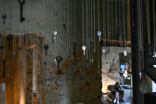 Gros plan sur des clés de maisons détruites, suspendues à des fils au musée Beit Beirut