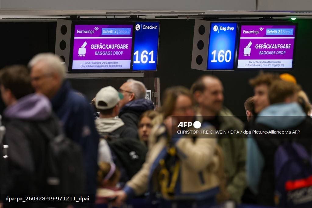 File de voyageurs patientant devant les comptoirs d'enregistrement dans le hall d'un aéroport européen