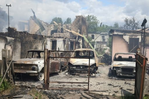 Voitures calcinées devant des maisons détruites par des frappes russes à Vychneve, près de Kiev
