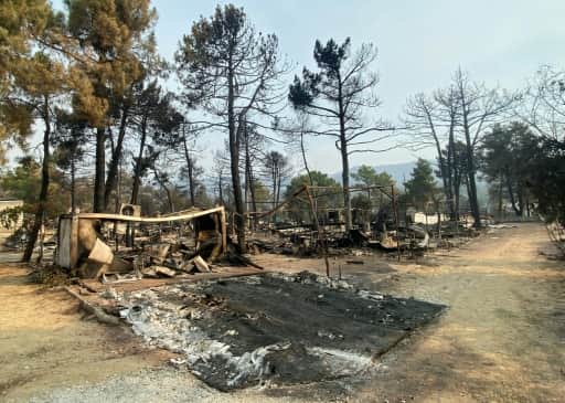 Carcasses de caravanes et arbres calcinés dans un camping détruit par le feu à l'ouest de Madrid