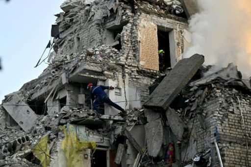 Immeuble résidentiel détruit par une frappe russe à Kiev, entouré de secouristes
