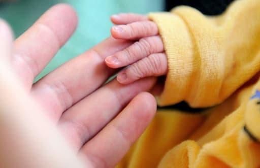 La main d'un nouveau-né posée dans celle d'un adulte