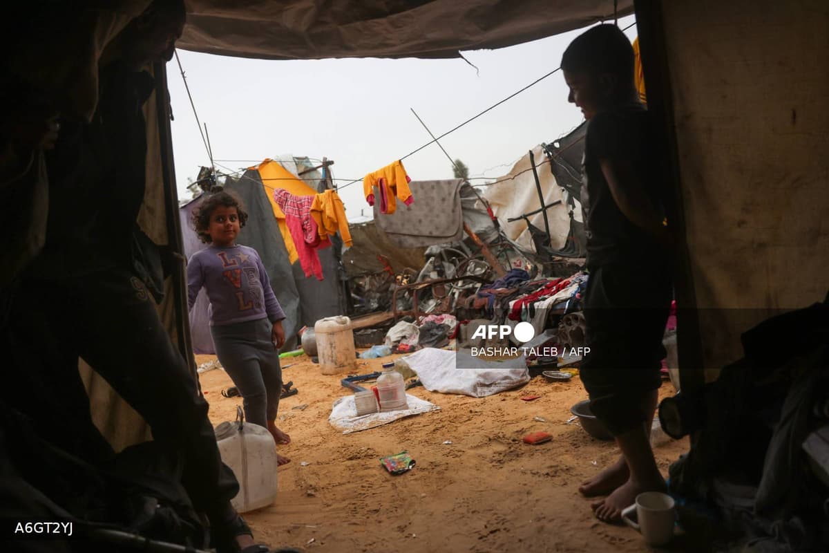 Enfants dans un campement de personnes déplacées au milieu des décombres, dans la bande de Gaza