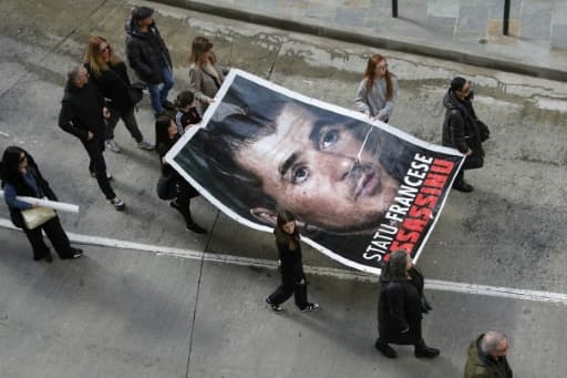 Un portrait géant d'Yvan Colonna porté par des manifestants dans une rue de Bastia