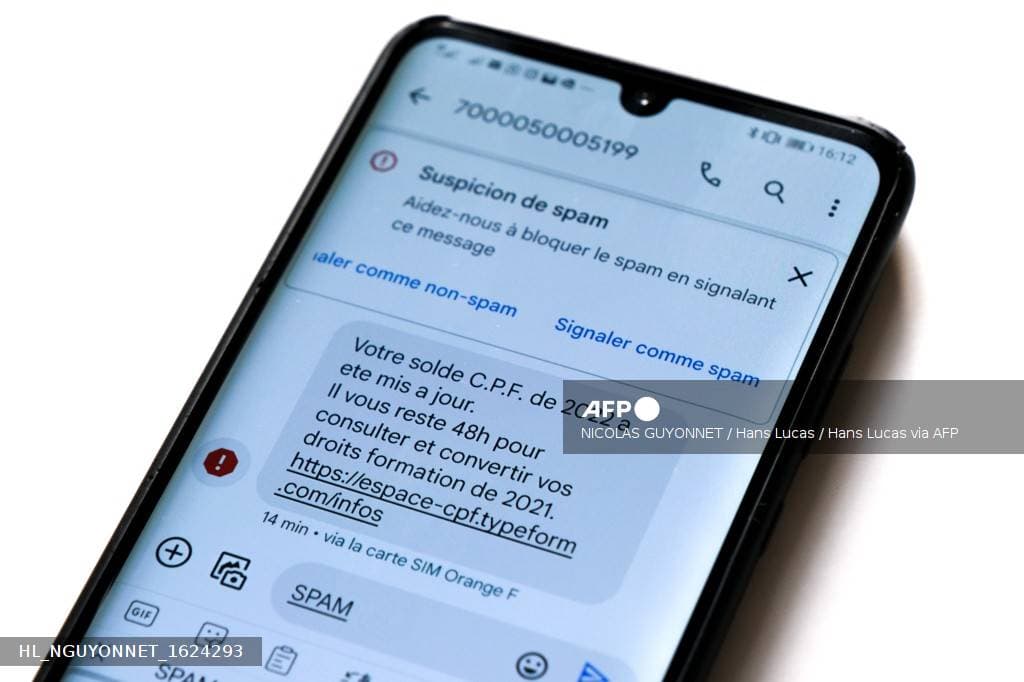 Écran de téléphone affichant un message frauduleux, signalé comme spam par la messagerie