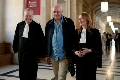 Dany Leprince marchant dans un couloir du palais de justice, entouré de ses deux avocats en robe
