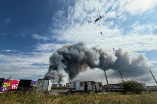 Un hélicoptère bombardier d'eau au-dessus d'un entrepôt en feu près de Moscou