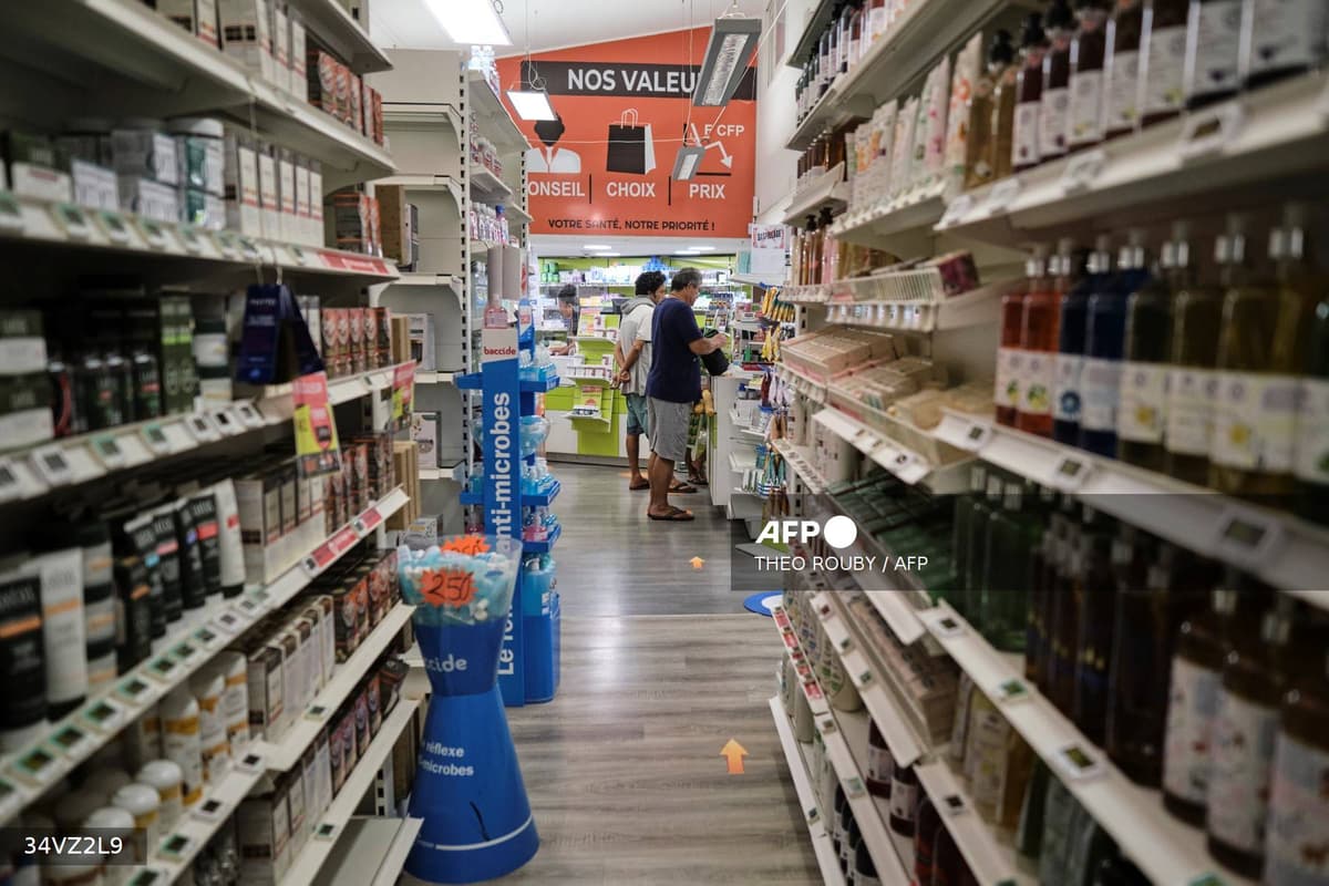 Intérieur d'une pharmacie française avec rayonnages remplis et clients au comptoir
