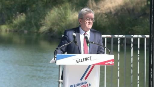 Jean-Luc Mélenchon parle à un pupitre en plein air, au bord de l'eau