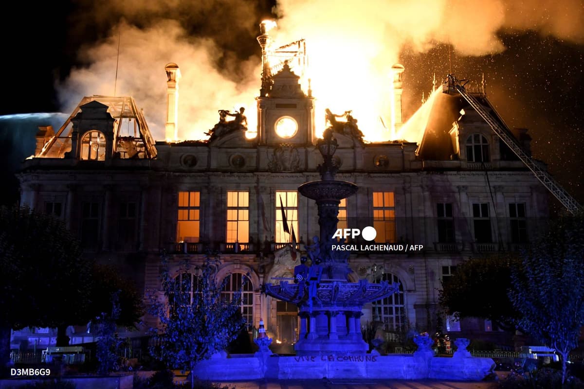 L'hôtel de ville de Limoges en flammes la nuit, toiture embrasée, une échelle de pompiers à droite