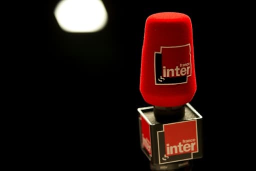 Un micro rouge portant le logo de France Inter, sur fond noir