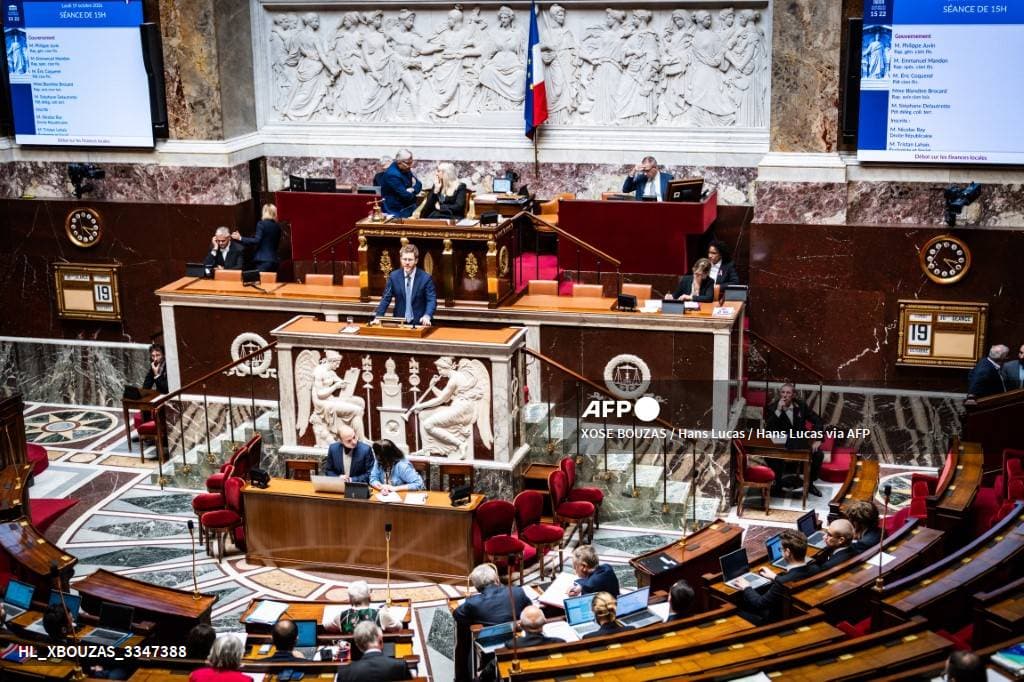 L'hémicycle de l'Assemblée nationale, un orateur à la tribune, les écrans annonçant le débat sur les finances locales