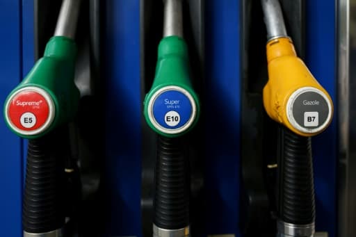 Trois pistolets de pompe à carburant, deux verts pour l'essence et un jaune pour le gazole