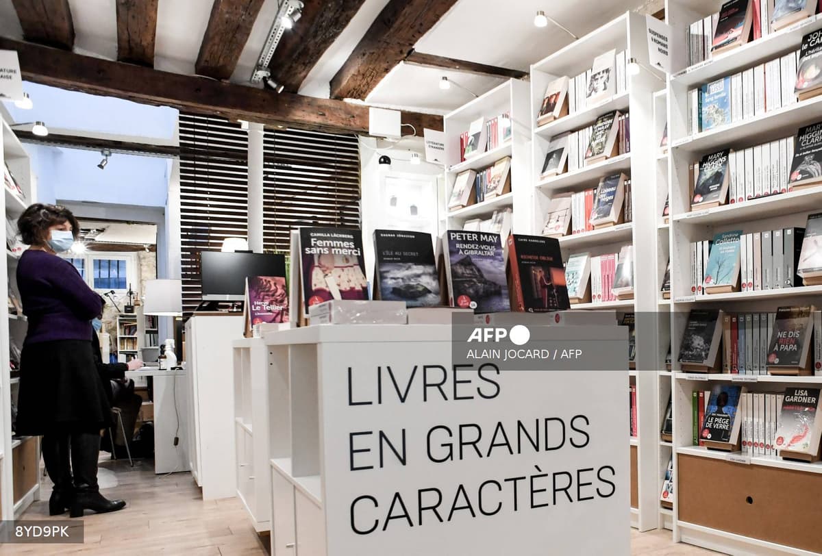 Intérieur d'une librairie indépendante française avec poutres apparentes et rayonnages de livres