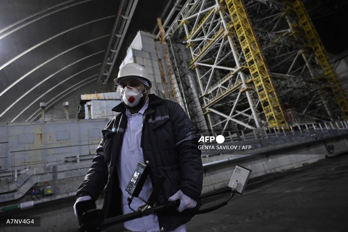 Un technicien portant un masque et un compteur Geiger sous l enceinte de confinement de Tchernobyl, le 14 avril 2026