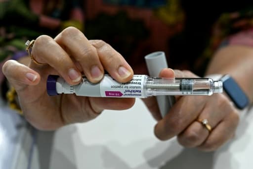 Des mains tiennent un stylo injecteur de Mounjaro et sa boîte