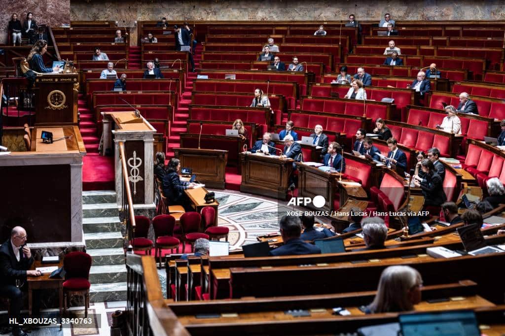 Vue de l'hémicycle de l'Assemblée nationale en séance, des députés à leurs bancs, une oratrice à la tribune