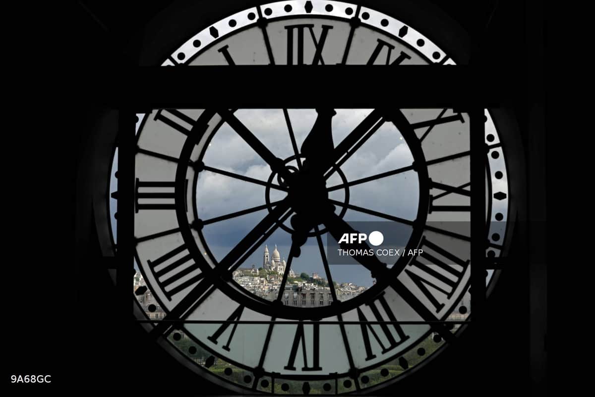 Le cadran géant de l'horloge du musée d'Orsay, à travers lequel on aperçoit la basilique du Sacré-Cœur
