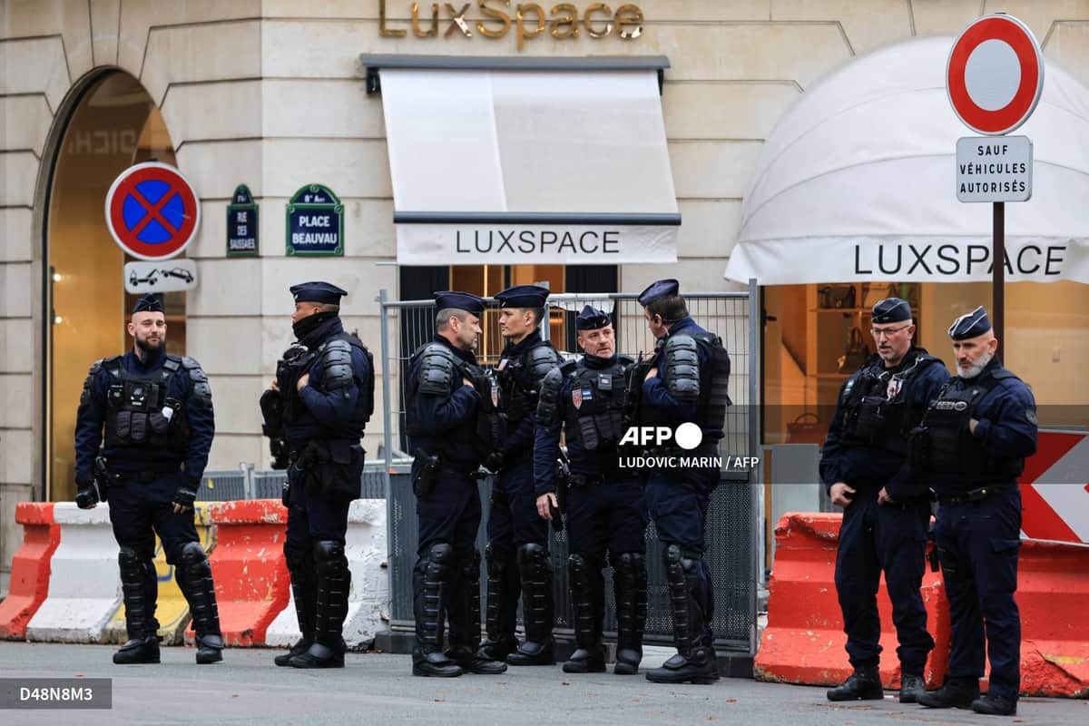 Des policiers des CRS en tenue de maintien de l'ordre devant des barrières, place Beauvau